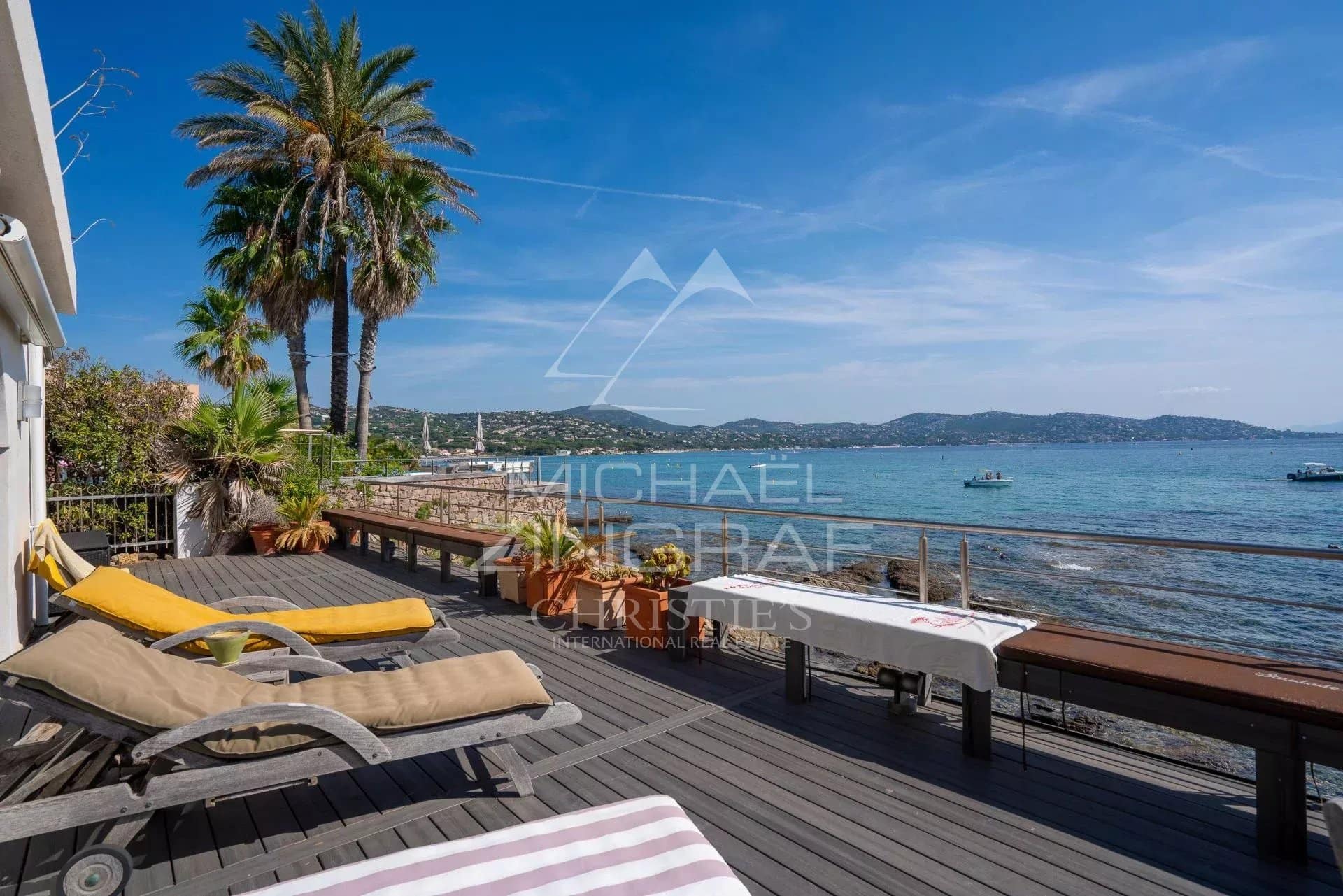 Terrasse en bois avec chaises longues surplombant la mer à Sainte-Maxime.