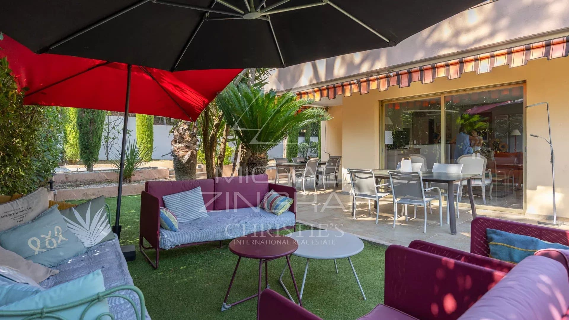 Espace extérieur d'une propriété à Mandelieu-la-Napoule avec salon de jardin et parasol.
