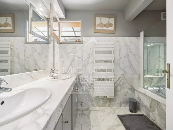 Salle de bain moderne avec carrelage en marbre et équipements contemporains.
