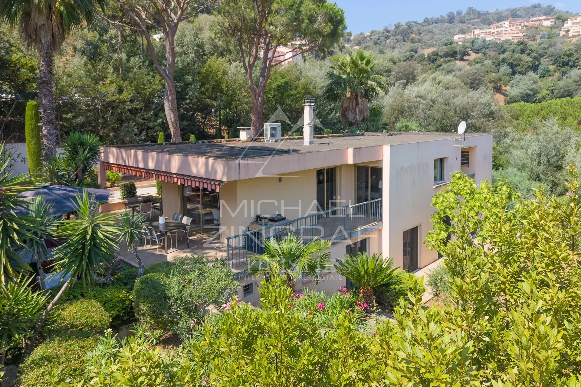 Propriété moderne entourée de verdure à Mandelieu-la-Napoule, avec terrasses et espace de réception lumineux.