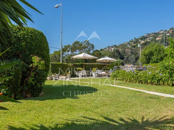 Landscaped garden with parasols and views of the hills in Théoule-sur-Mer