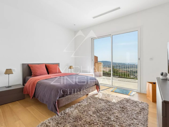 Chambre d'une villa avec vue mer à Mandelieu-la-Napoule, décorée avec un lit et un accès à un balcon.