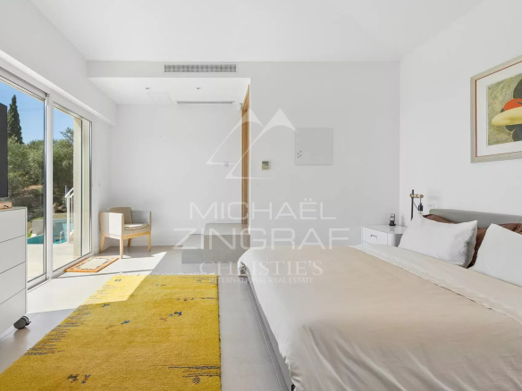 Chambre lumineuse avec accès à l'extérieur, vue sur la piscine, dans une villa à Mandelieu-la-Napoule.