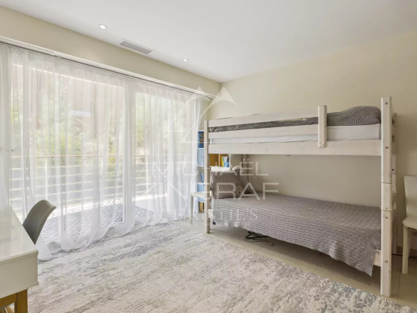 Room in a contemporary apartment in Théoule-sur-Mer with bunk bed and access to a balcony.