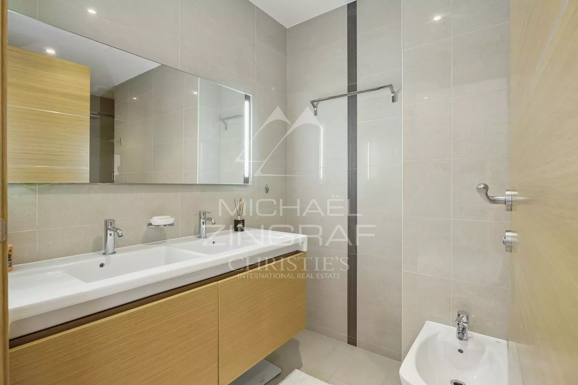 Bathroom of a contemporary apartment Modern bathroom with wooden furniture, mirror and shower.
