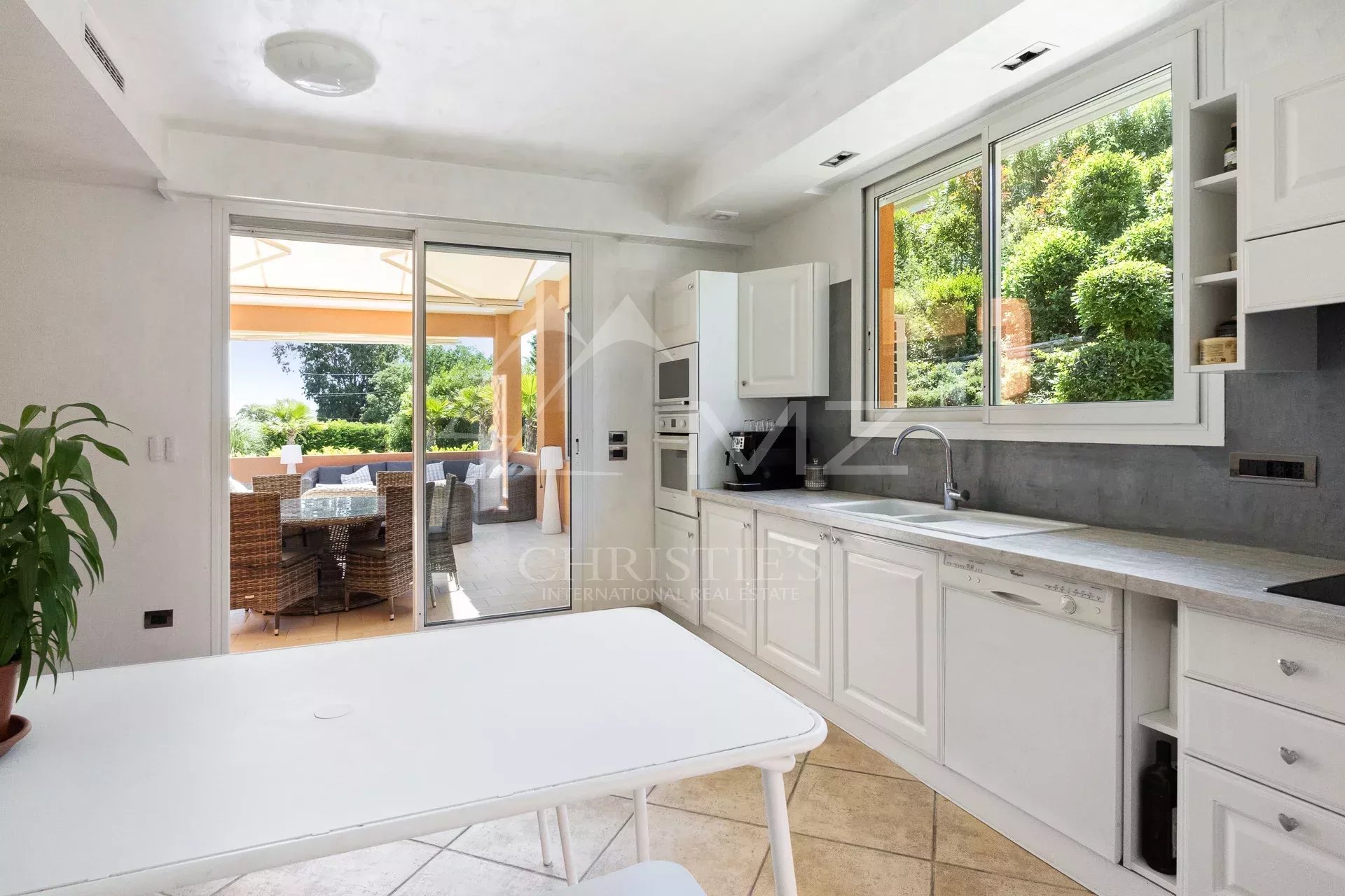 Cuisine moderne avec vue sur un patio extérieur dans une villa à Mandelieu-la-Napoule.