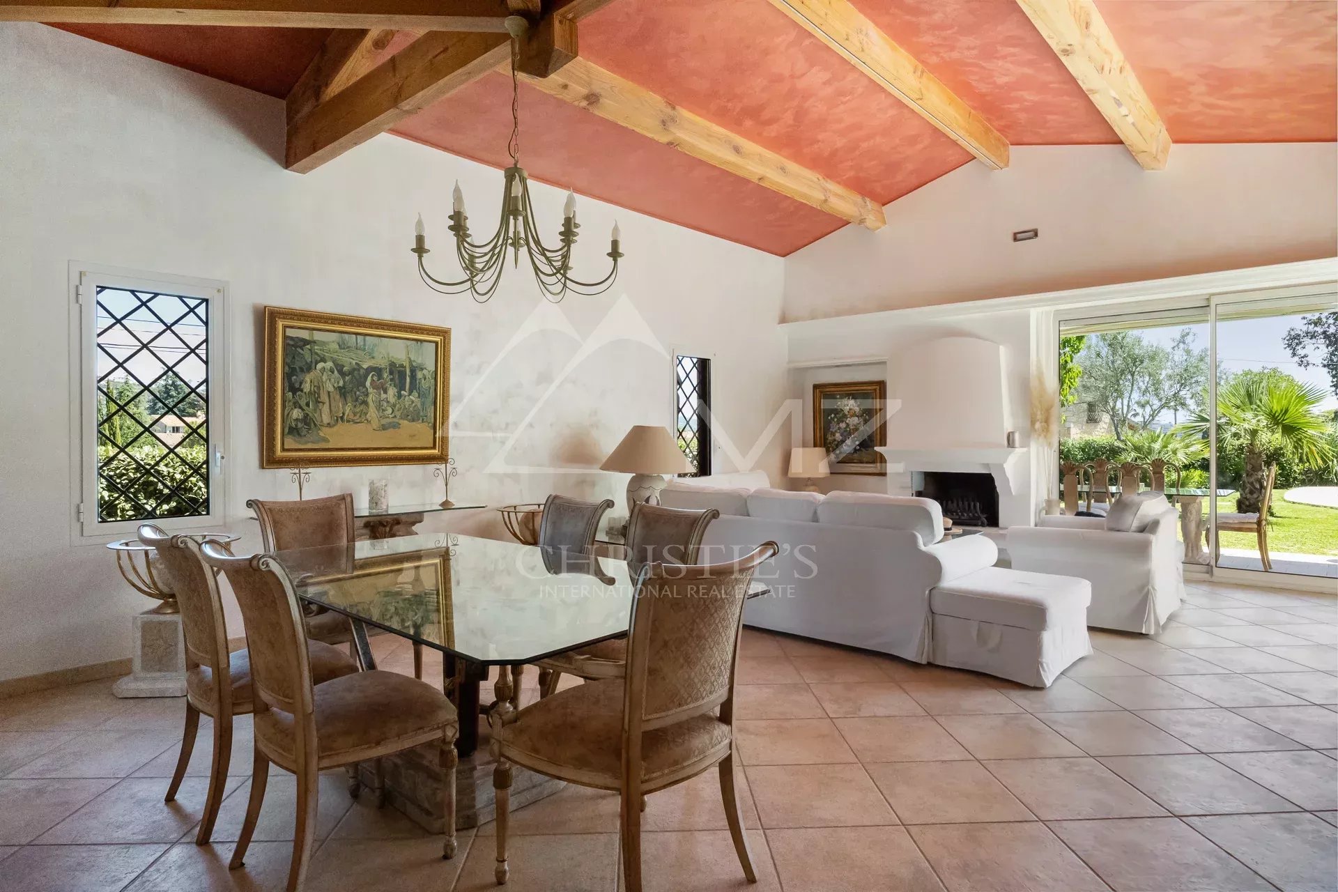Intérieur d'une villa de plain-pied avec salle à manger et salon, fenêtres avec vue sur l'extérieur.