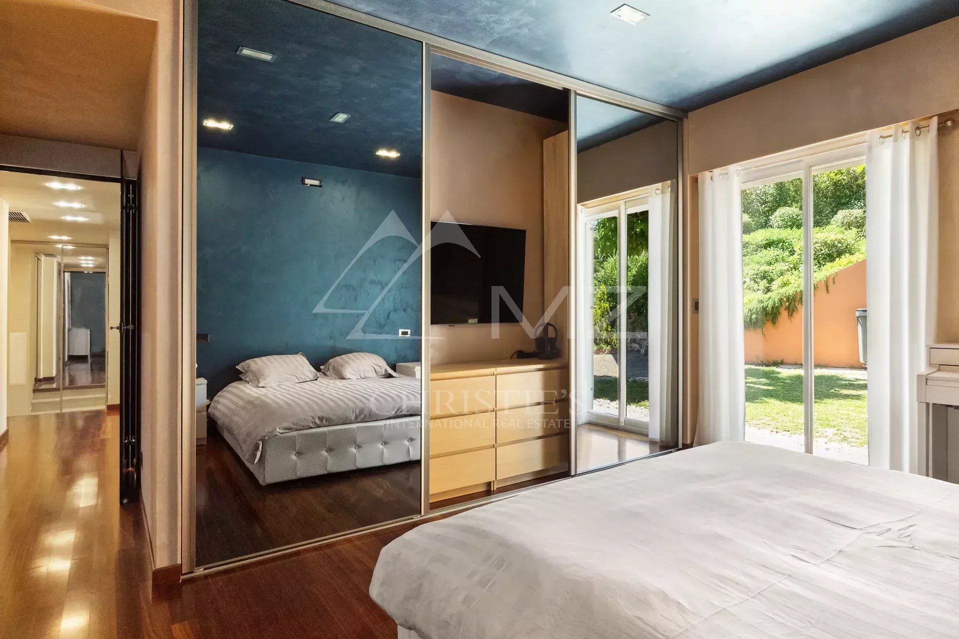 Chambre d'une villa de plain-pied avec miroir et accès à l'extérieur, Mandelieu-la-Napoule.