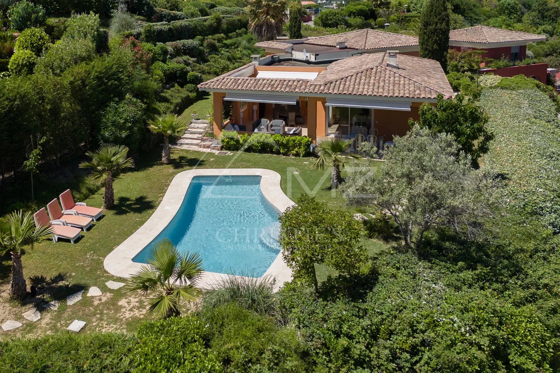 Villa de plain-pied avec piscine dans un domaine privé à Mandelieu-la-Napoule, entourée de verdure.