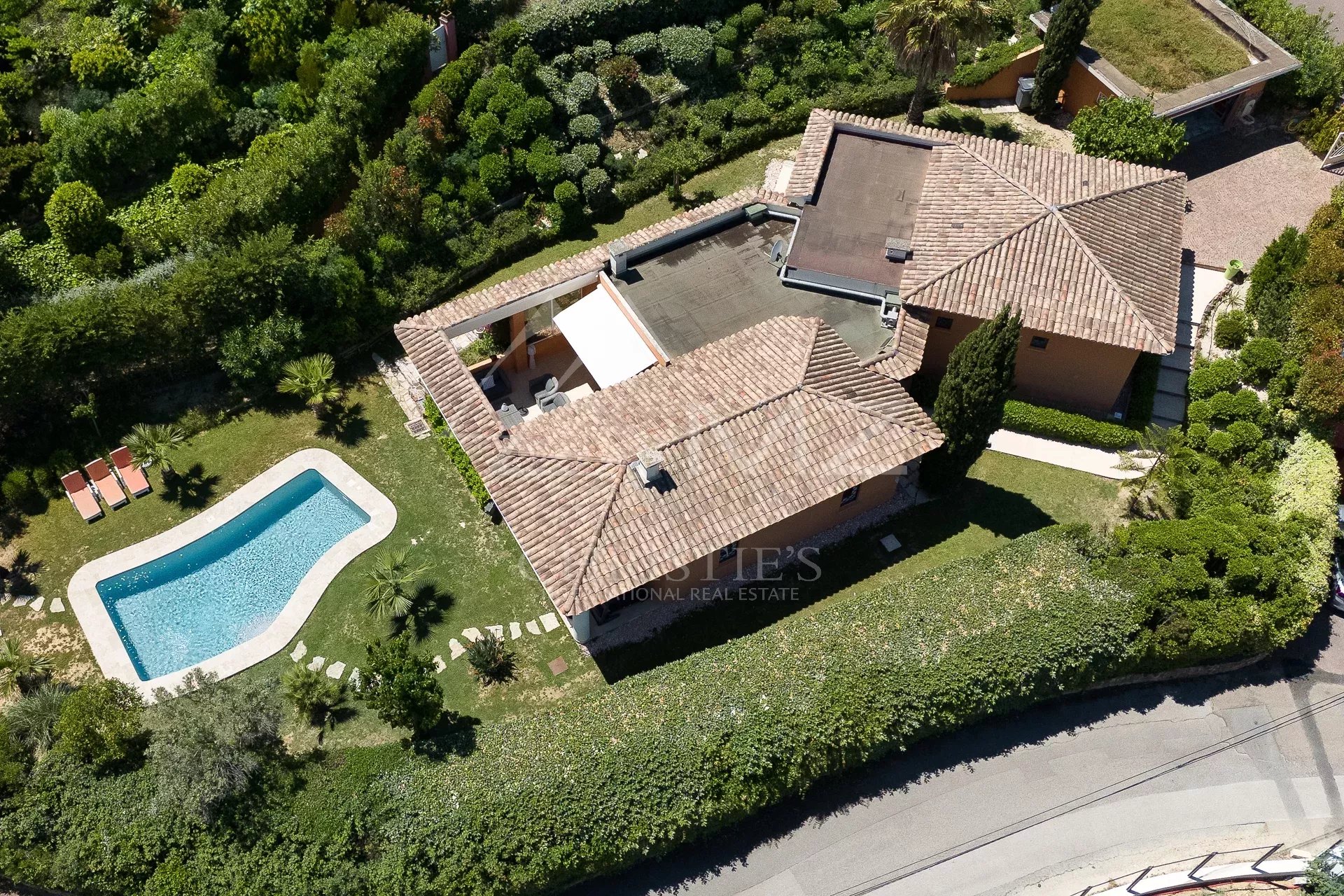 Vue aérienne d'une villa de plain-pied avec piscine et jardin dans un domaine privé à Mandelieu-la-Napoule.