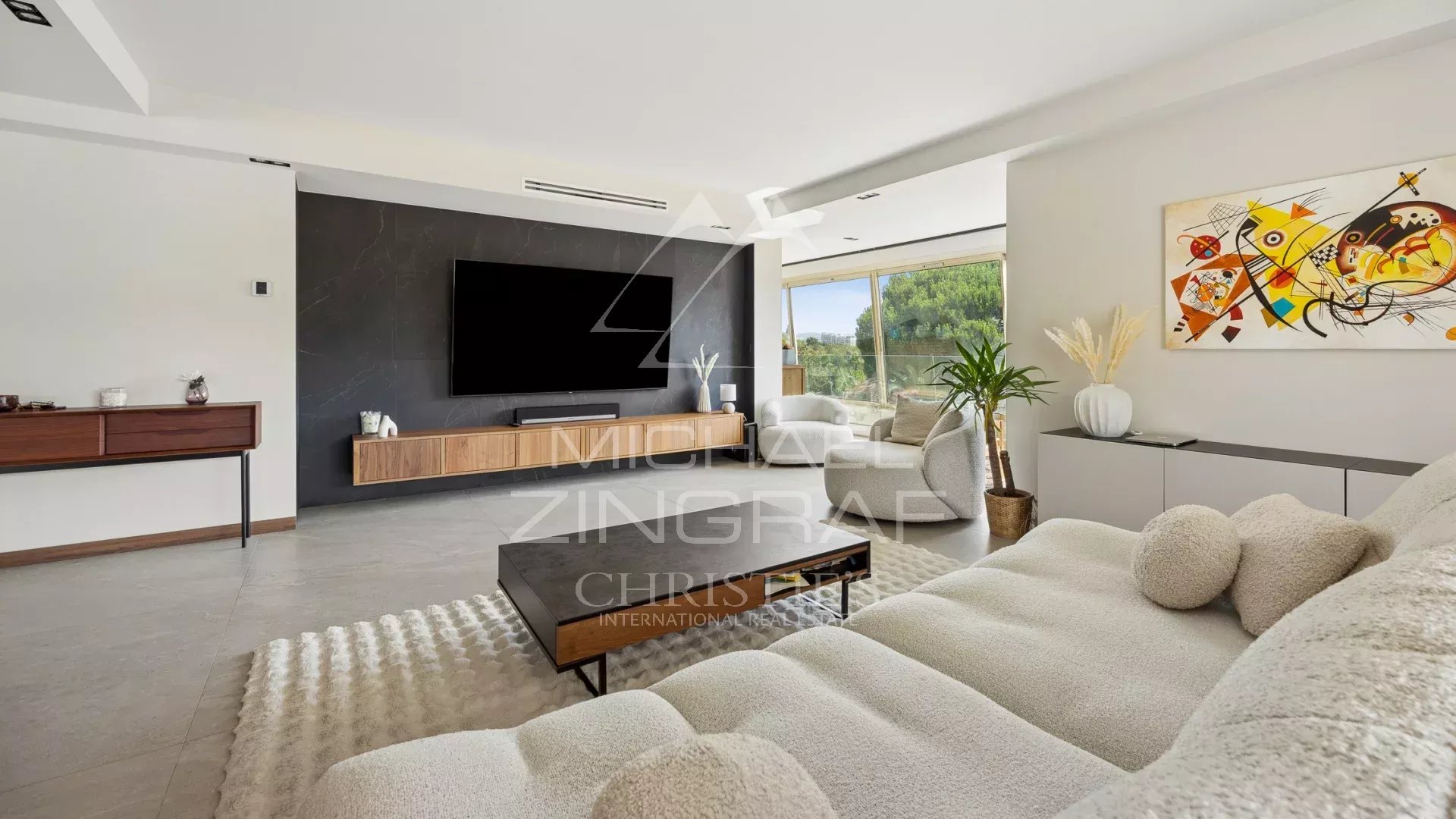 Intérieur d’un appartement à Mandelieu-la-Napoule Intérieur d'un appartement moderne avec salon, télévision et accès à l'extérieur.