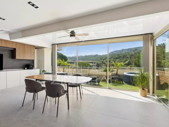 Intérieur d'un appartement moderne avec un espace de vie lumineux et une vue sur la nature.