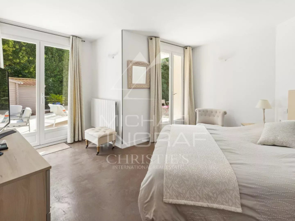 Chambre d'une maison avec accès à une terrasse et vue sur le jardin.