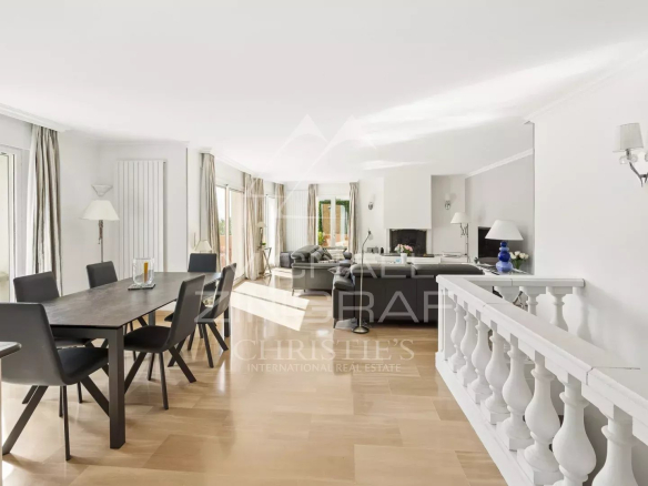 Intérieur d'une maison avec salle à manger et salon lumineux, vue sur jardin.