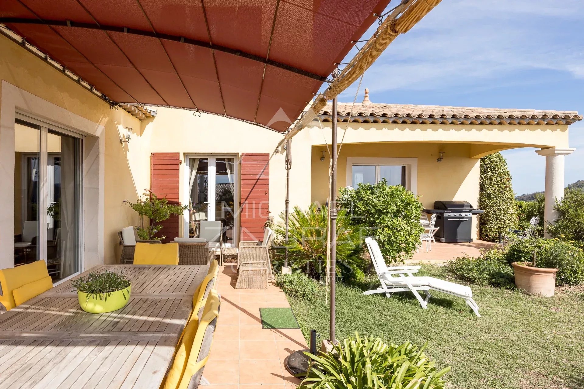 Terrace of a Provençal villa in Mandelieu-la-Napoule Terrace of a Provençal villa with garden furniture and view of the garden and swimming pool.
