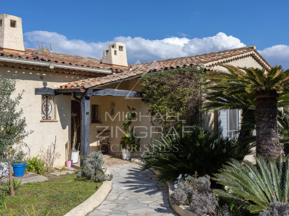 Entrance to an elegant family home in Mandelieu-La Napoule with garden and stone path.