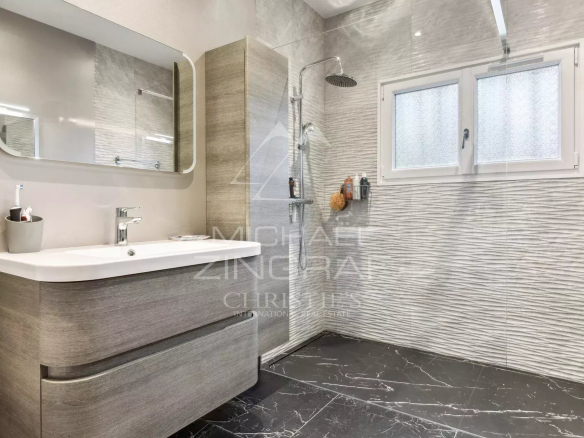 Modern bathroom with shower and wooden furniture, black and white tiles.
