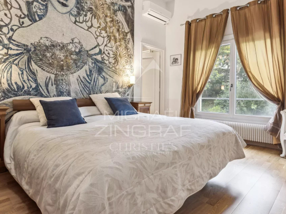 Bedroom in a family home in Mandelieu-La Napoule with a large bed and elegant curtains.