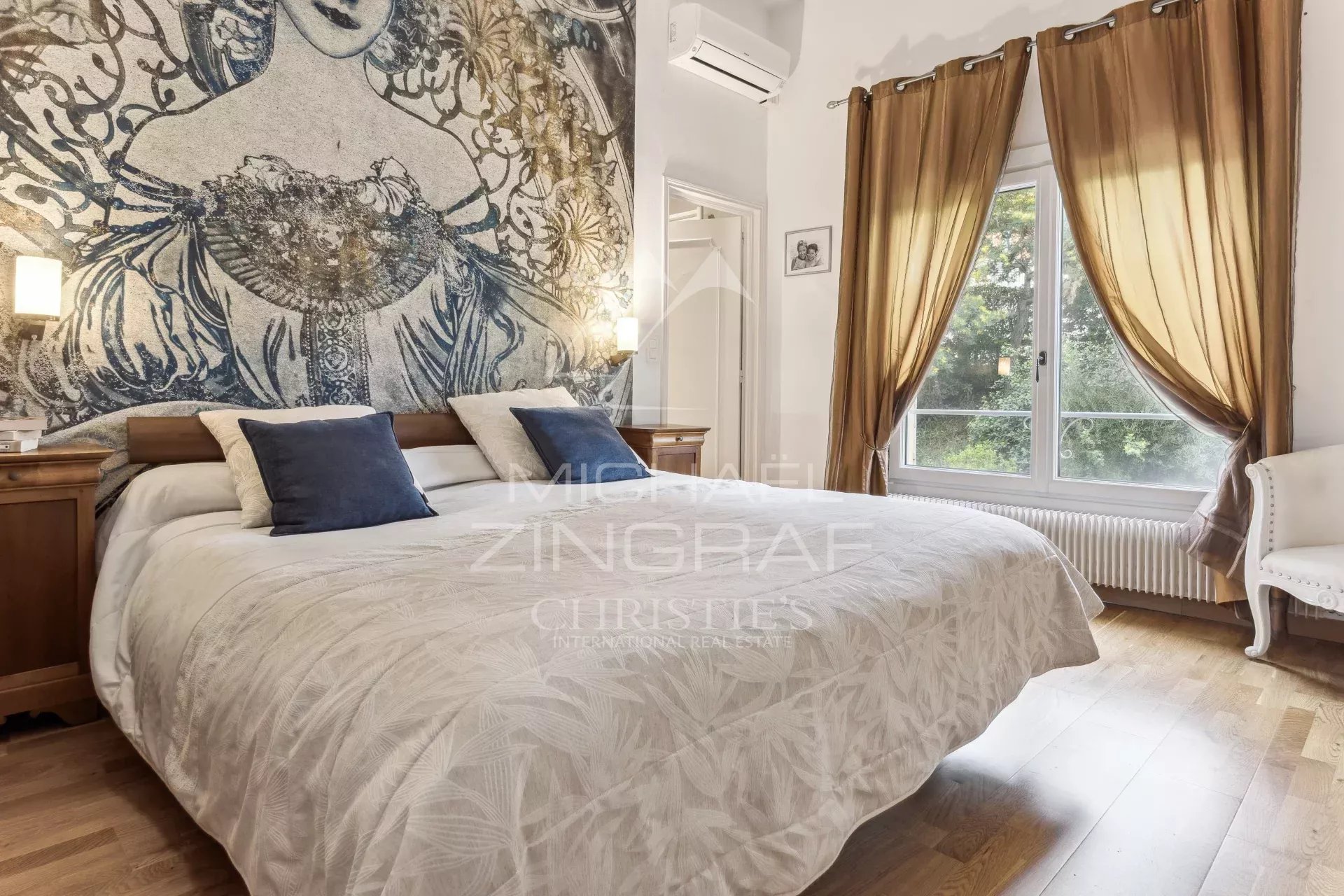 Bedroom in a family home in Mandelieu-La Napoule with a large bed and elegant curtains.