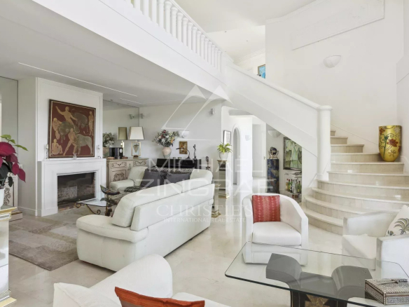 Intérieur d'une villa moderne avec salon lumineux et escalier, située à Mandelieu-la-Napoule.