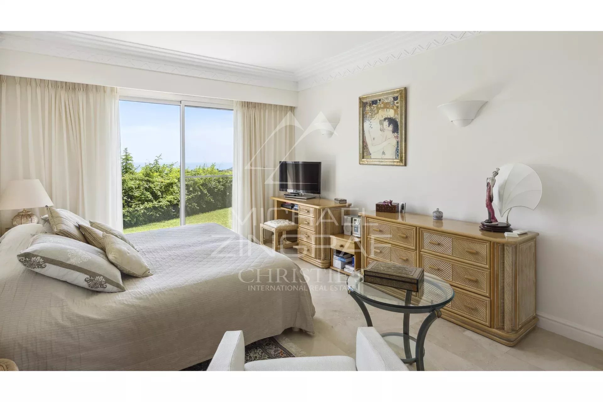 Chambre de villa à Mandelieu-la-Napoule Chambre d'une villa avec vue sur la mer, mobilier élégant et accès à un jardin.