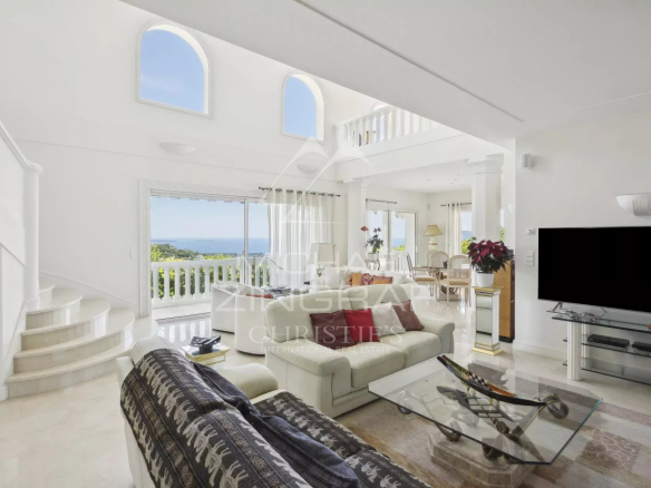 Intérieur d'une villa moderne avec vue sur la mer, salon lumineux et élégant à Mandelieu-la-Napoule.