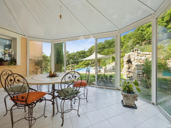 Salle à manger lumineuse avec vue sur la piscine et le jardin dans une villa aux Adrets-de-l'Estérel.