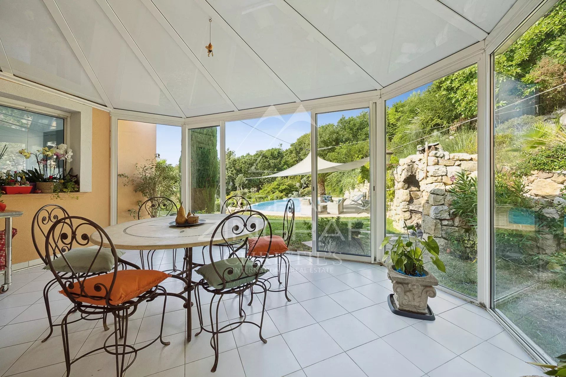 Salle à manger avec vue sur la piscine Salle à manger lumineuse avec vue sur la piscine et le jardin dans une villa aux Adrets-de-l'Estérel.
