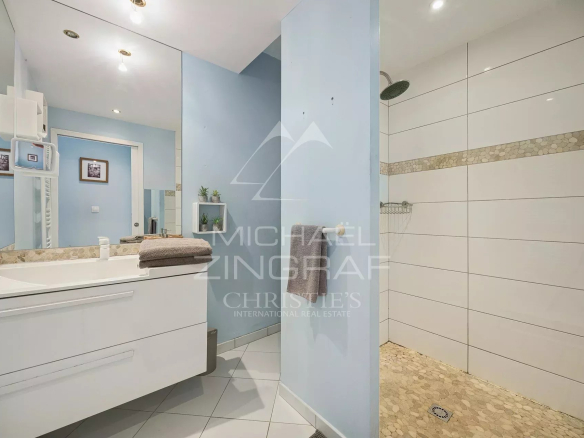 Salle de bain moderne avec douche et lavabo dans une villa