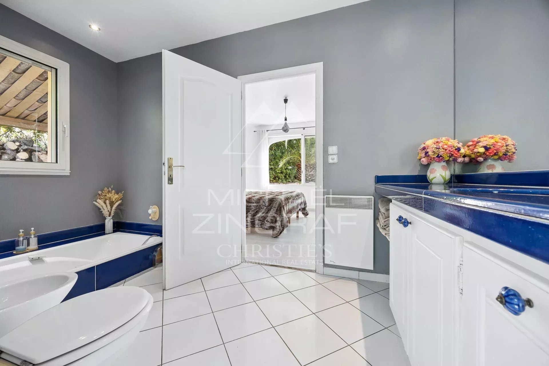 Salle de bains élégante Salle de bains moderne avec baignoire et lavabo, carrelage blanc et murs gris.