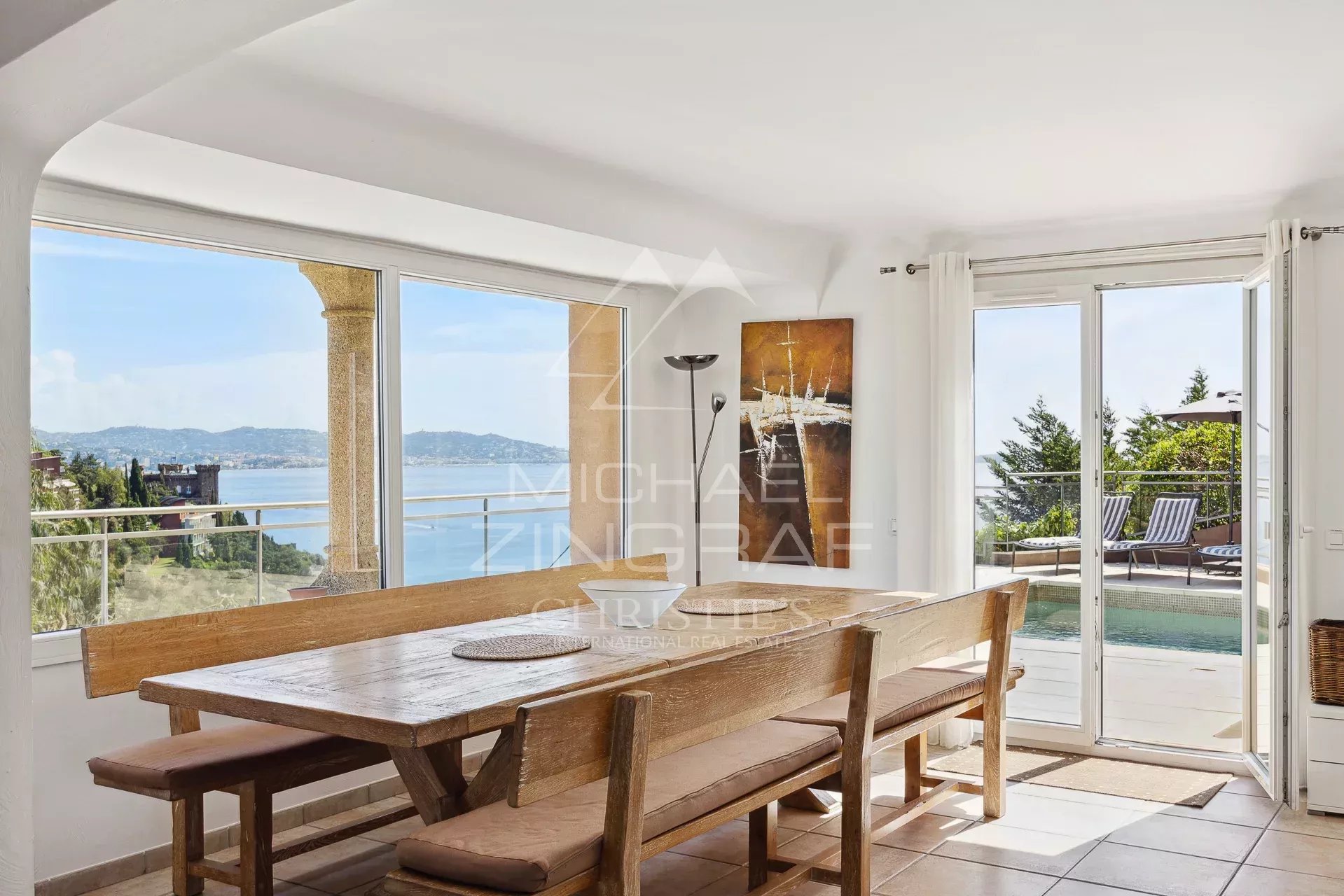 Salle à manger avec vue sur la mer Intérieur d'une maison avec vue mer, salle à manger en bois et grandes baies vitrées.