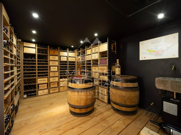 Cave à vin avec étagères en bois et fûts dans une propriété de charme.