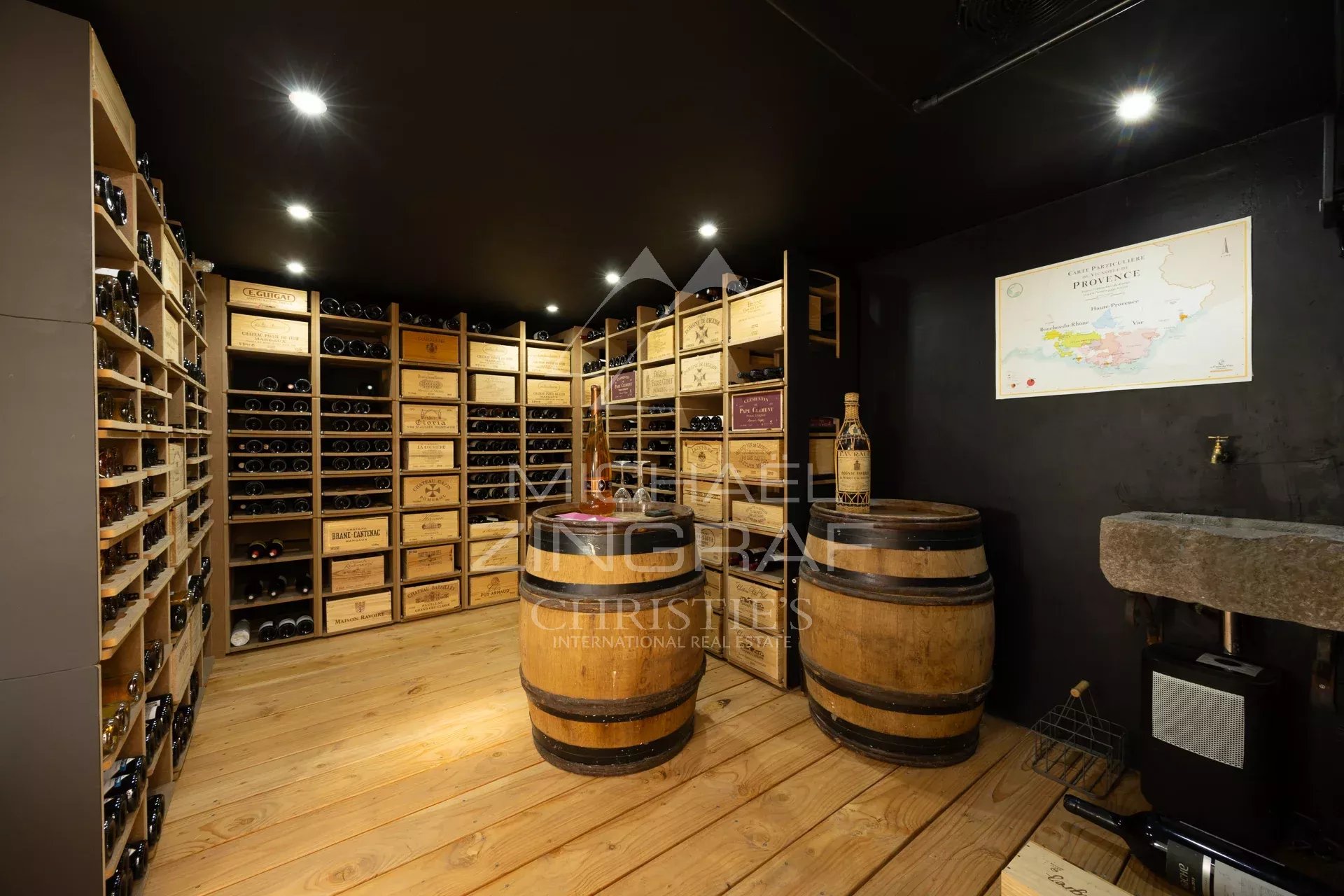 Cave à vin avec étagères en bois et fûts dans une propriété de charme.