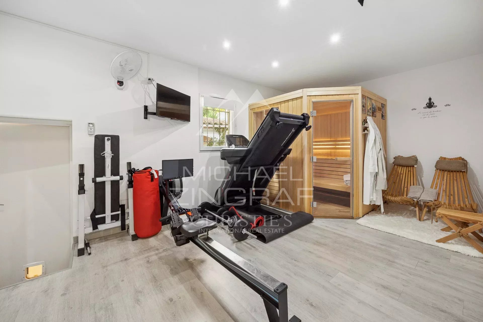 Salle de sport avec équipements, sauna et espace de détente.