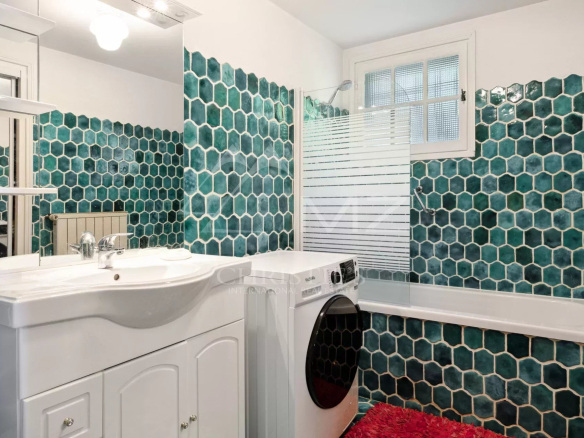 Salle de bain avec carrelage hexagonal vert et baignoire à Anthéor.