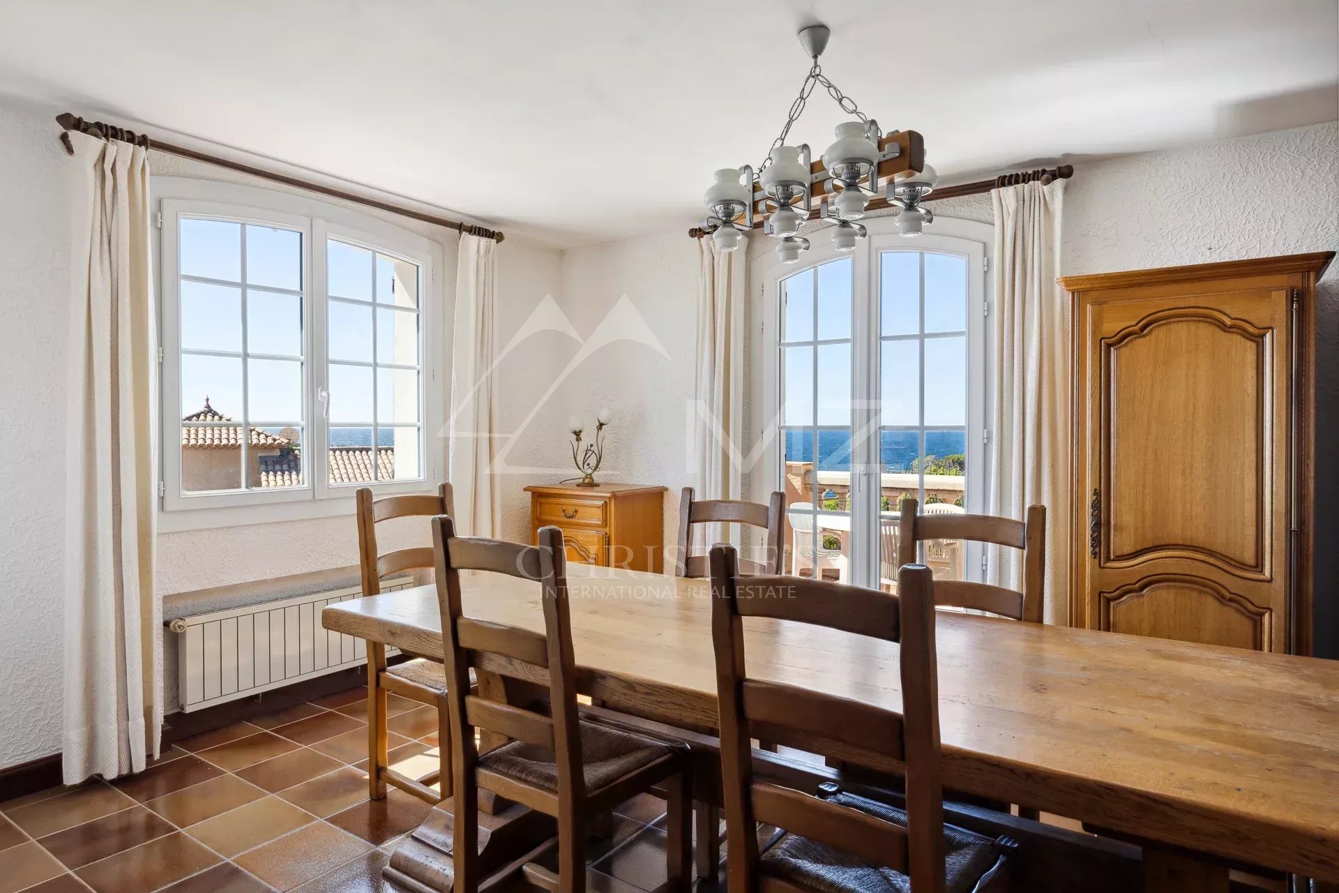 Salle à manger avec vue à Anthéor Salle à manger avec vue sur la mer, fenêtres ouvertes, mobilier en bois, à Anthéor.