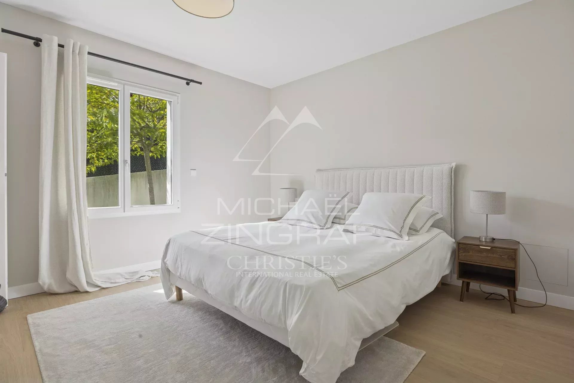 Chambre d'une villa contemporaine rénovée à Mandelieu-la-Napoule avec vue sur les collines de l'Estérel.