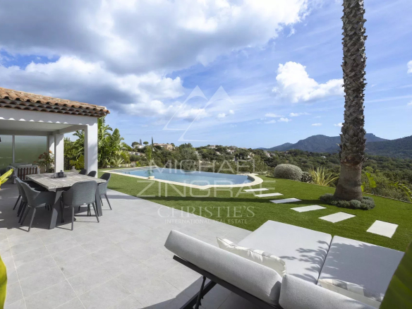 Vue extérieure d'une villa contemporaine avec piscine et jardin, entourée de collines à Mandelieu-la-Napoule.