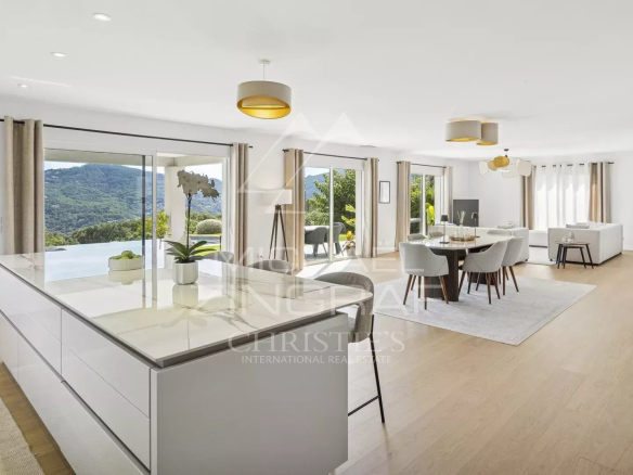 Intérieur d'une villa contemporaine avec vue sur les collines de l'Estérel, salon lumineux et espace repas.