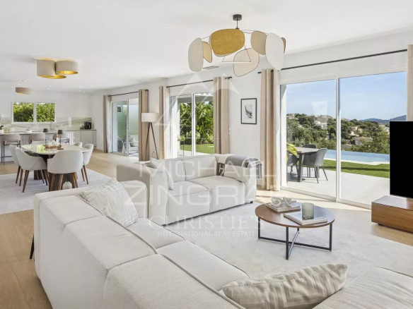 Intérieur d'une villa contemporaine à Mandelieu-la-Napoule, salon lumineux avec vue sur les collines.