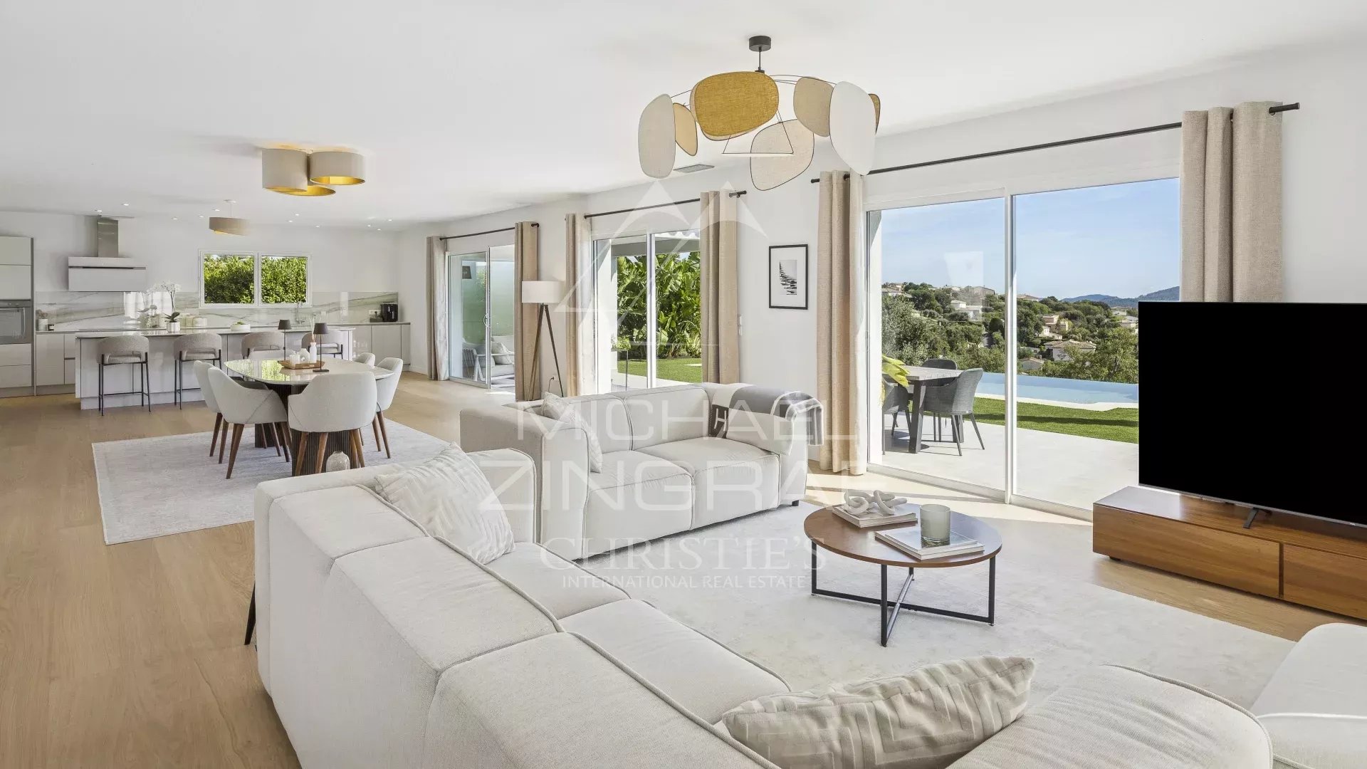 Intérieur d'une villa contemporaine à Mandelieu-la-Napoule, salon lumineux avec vue sur les collines.