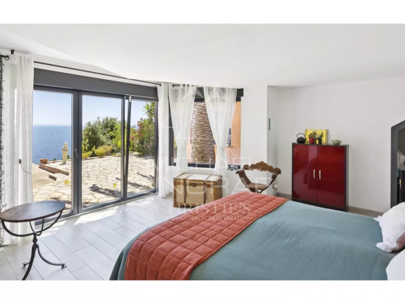 Chambre d'une propriété rénovée avec vue sur la mer à Anthéor, fenêtres ouvertes sur l'extérieur.