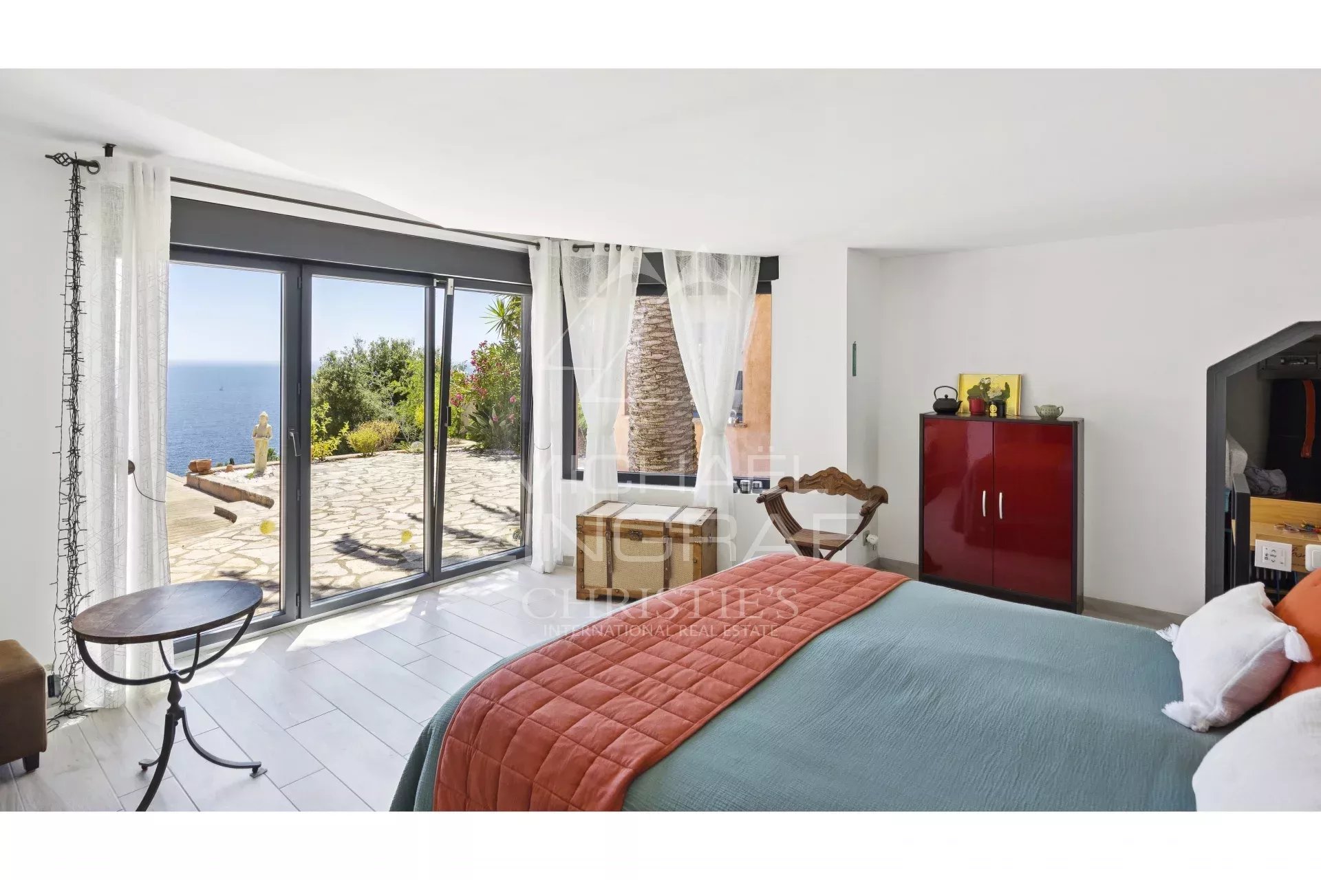 Chambre d'une propriété rénovée avec vue sur la mer à Anthéor, fenêtres ouvertes sur l'extérieur.