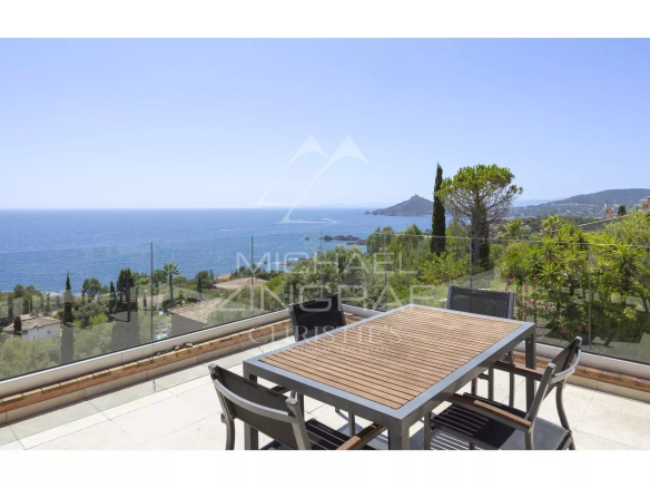 Terrasse avec vue mer à Anthéor, mobilier de jardin en bois, paysage côtier en arrière-plan.