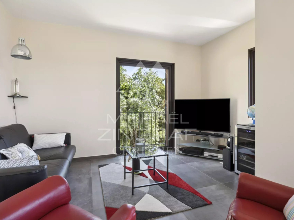 Intérieur d'une propriété rénovée avec salon moderne et télévision.