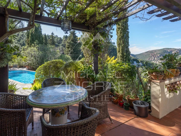 Terrasse d'une villa à Théoule-sur-Mer avec vue sur la mer et la nature, piscine visible en arrière-plan.