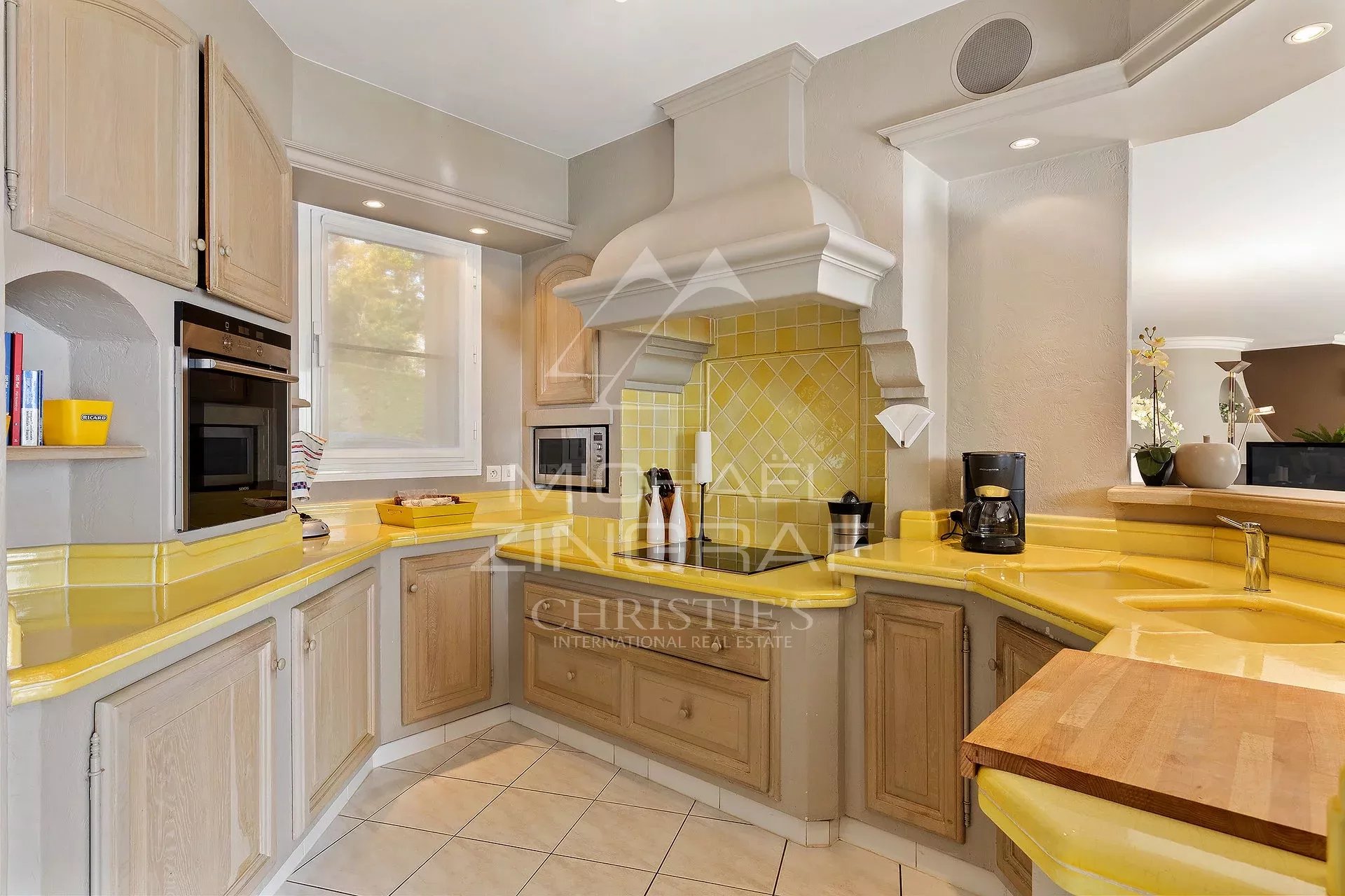 Cuisine de villa à Mandelieu-la-Napoule Cuisine lumineuse d'une villa à Mandelieu-la-Napoule, avec un plan de travail jaune et des équipements modernes.