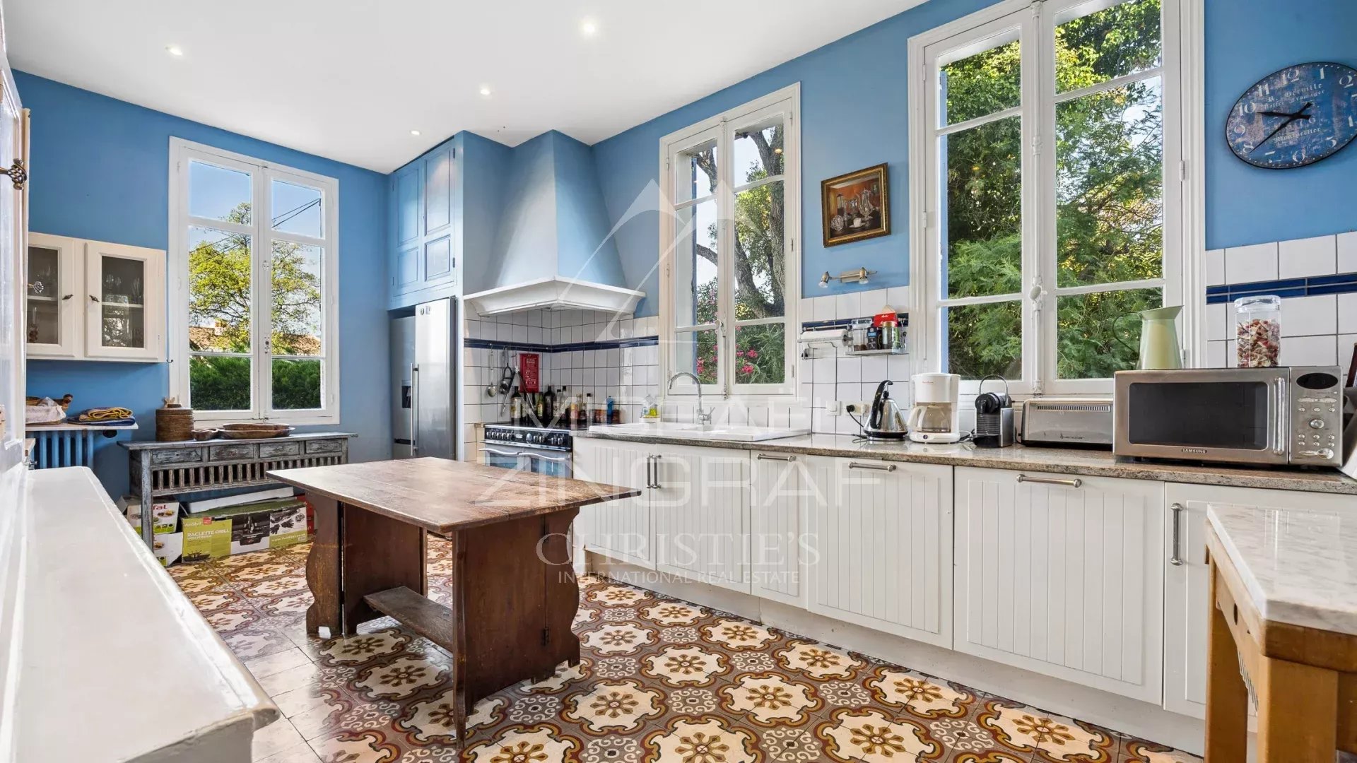 Cuisine d’une villa Belle Époque à Mandelieu-la-Napoule Cuisine spacieuse avec fenêtres et carrelage rétro dans une villa Belle Époque à Mandelieu-la-Napoule.