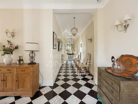 Intérieur d'une villa Belle Époque à Mandelieu-la-Napoule, avec un hall d'entrée au sol en damier.