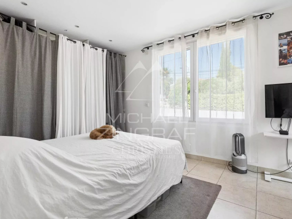 Room in a villa in Mandelieu-la-Napoule with bed, television and window letting in light.